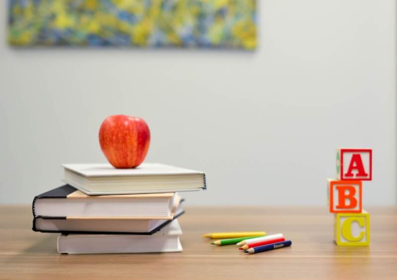 Mesa com artigos escolares e uma ma�a